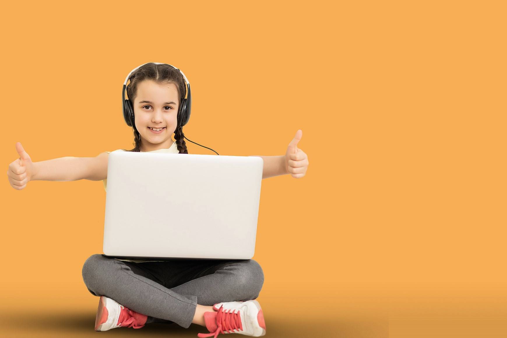 Full length photo of positive interested kid sit legs crossed folded work her laptop read social media news wear casual style clothing isolated over yellow color background.